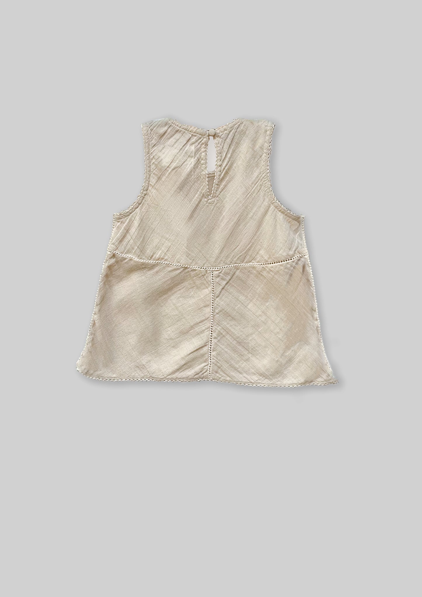 Off white sleeveless top on a gray background