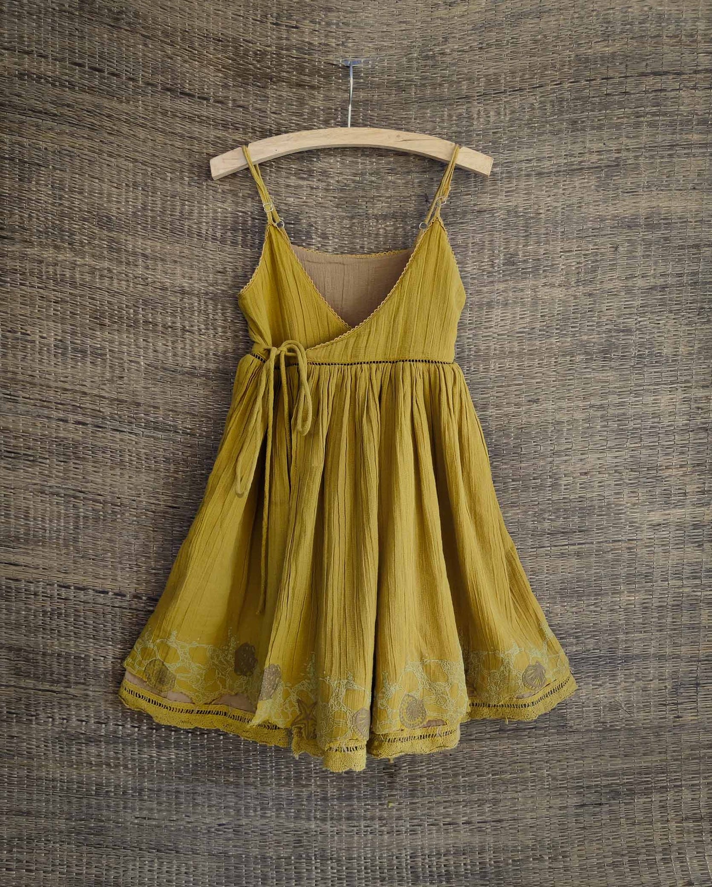 Front view of reversible cotton dress in golden yellow with star print with a lace sleeve