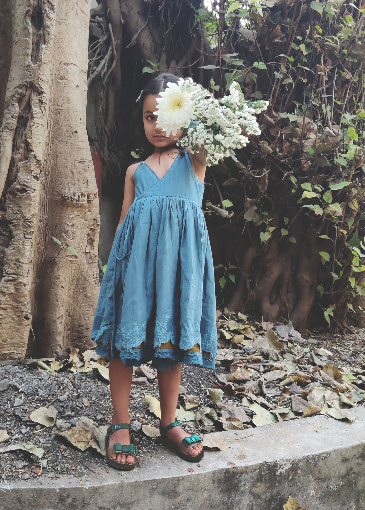 A child wearing a Blue and olive colour reversible dress