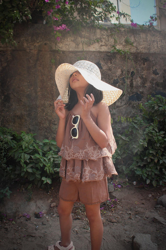 Playsuit - Mud TheKefiHouse The Kefi House kids' brown summer outfit featuring tiered ruffles and lace detail, paired with a sun hat, ideal for sunny days.