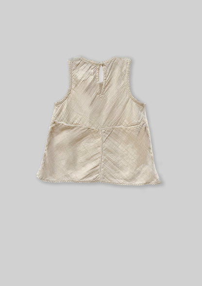 Off white sleeveless top on a gray background