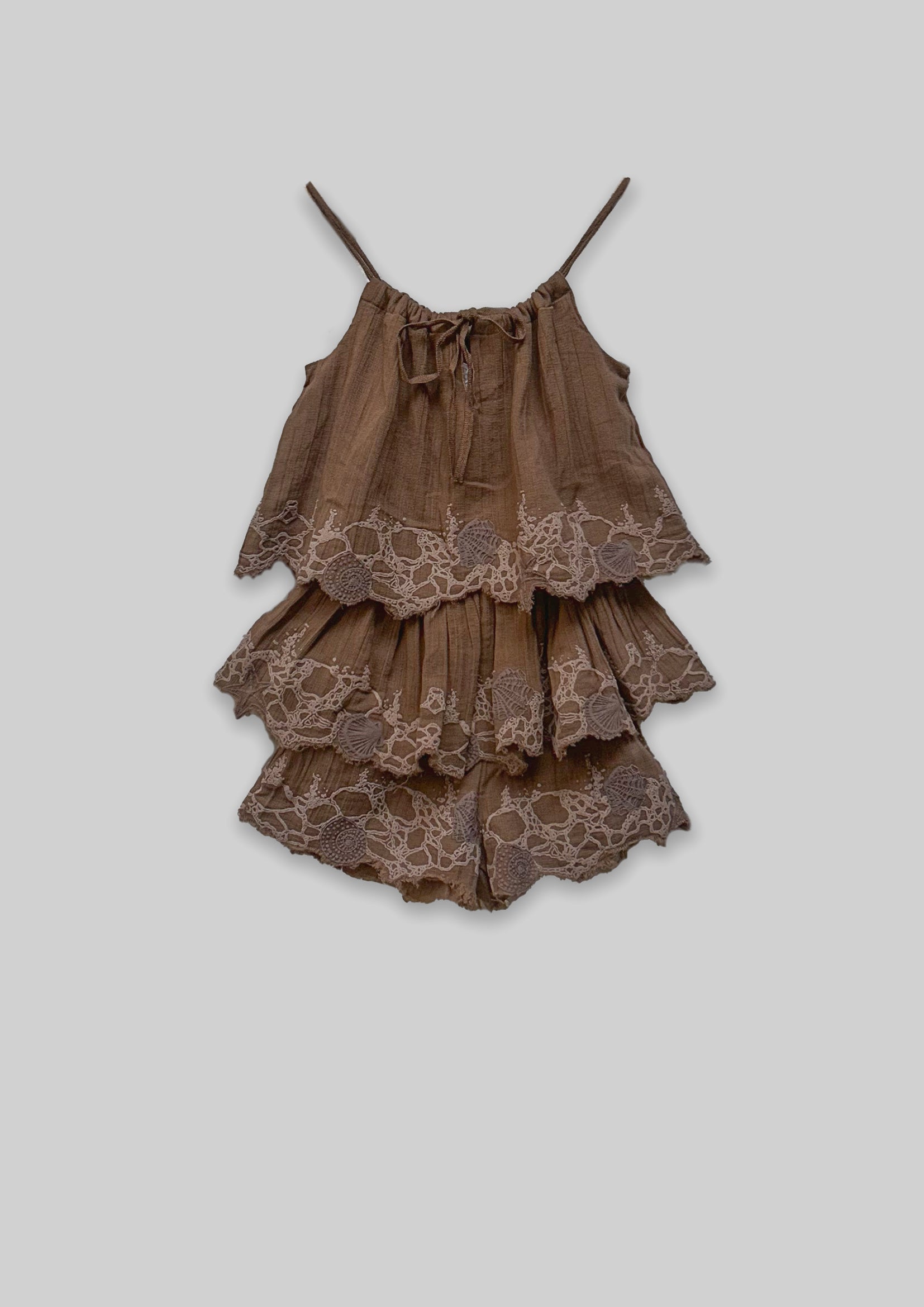 Brown tiered Jumpsuit with lace details on a light gray background