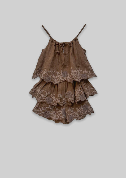 Brown tiered Jumpsuit with lace details on a light gray background