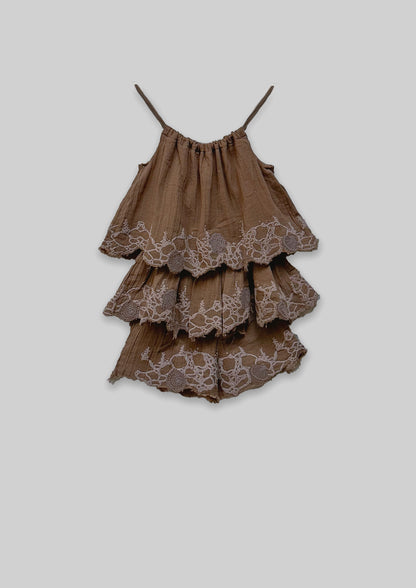 Brown tiered Jumpsuit with lace details on a light gray background
