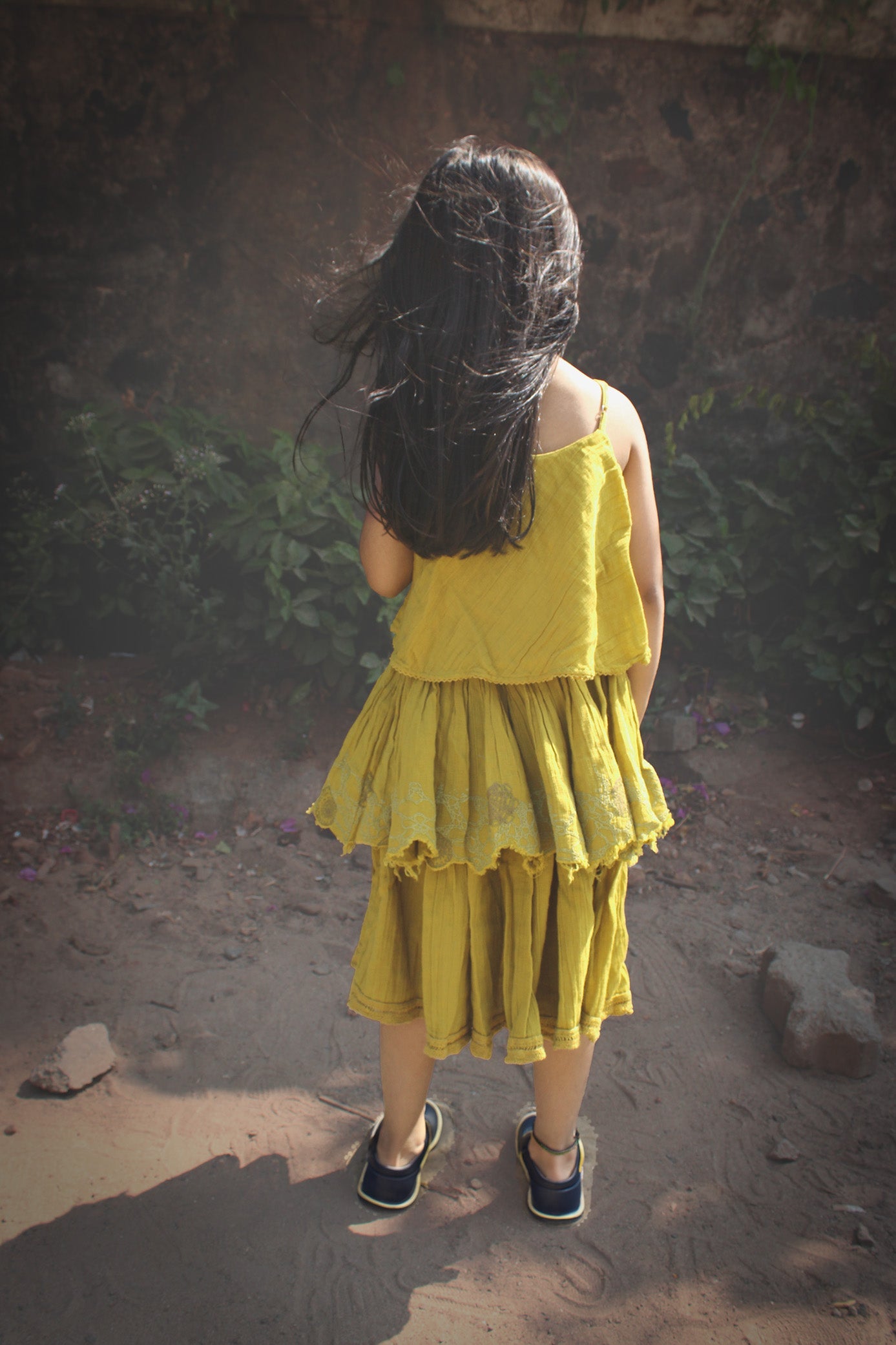 Back view of cotton layered dress with gathered waist and flowy silhouette