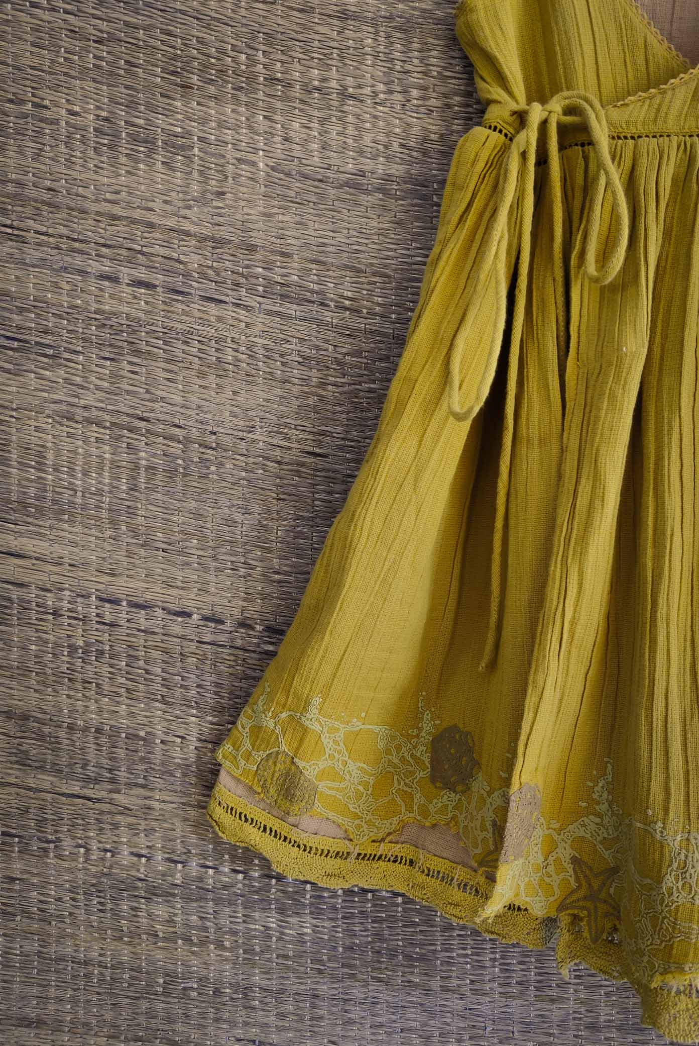 Close-up of star and shell print on golden yellow side of the dress