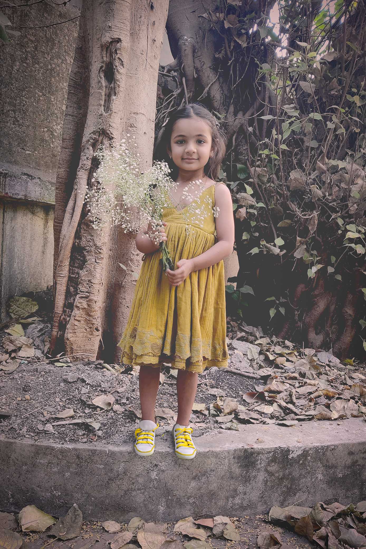 Child in a 100% cotton, breathable, reversible golden dress